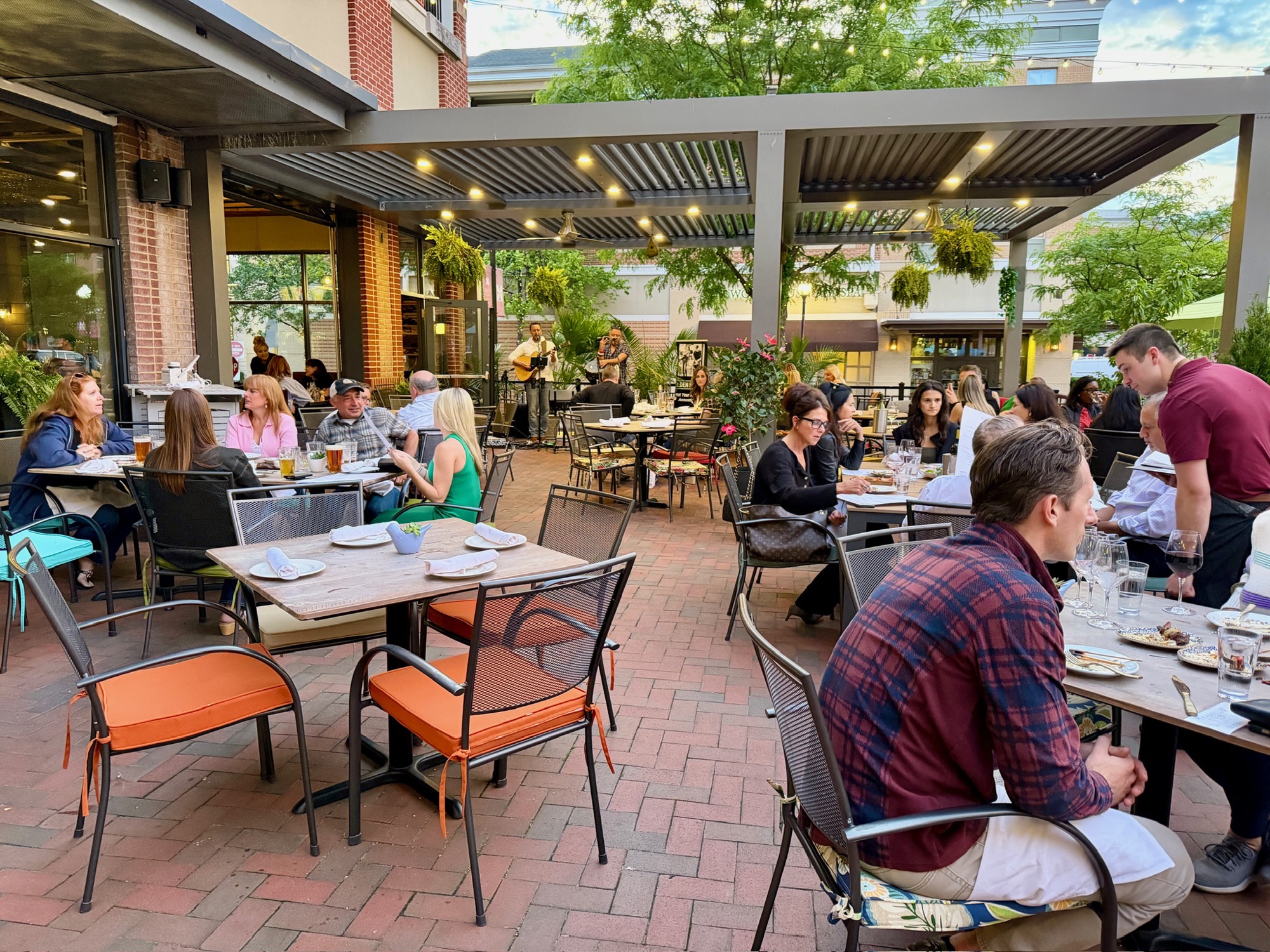 Falcon & Fig guests gathered on the patio under string lights with live music